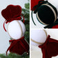 Velvet candy ornaments close-up: red and dark green/black with white centers and gold trim