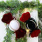 Velvet candy ornaments hanging on a Christmas tree: red and dark green/black with white centers