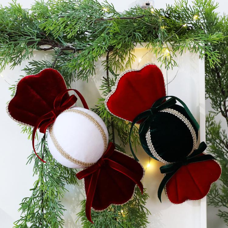 Velvet candy ornaments hanging on a Christmas tree: red and dark green/black with white centers