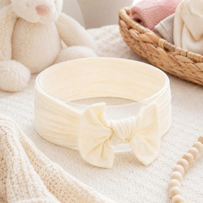 Infant hair bow headband in light beige with large fabric bow