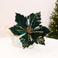 Dark green velvet poinsettia flower decoration with glittery accents, holiday DIY prop