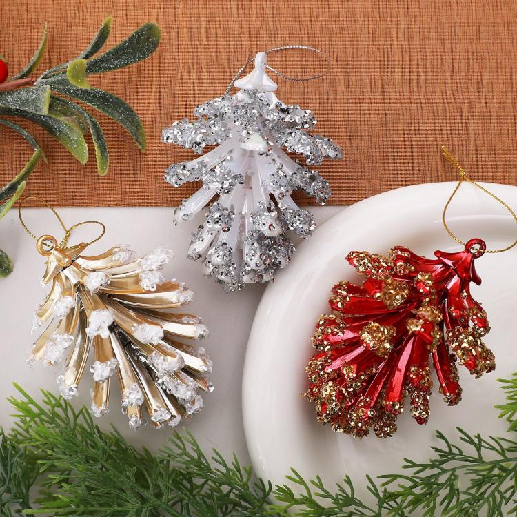 Assorted pinecone-style Christmas tree ornaments in white, gold, and red