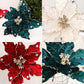 Four velvet poinsettia ornament close-ups in teal and red and white