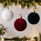Velvet inflatable Christmas ball ornaments in red, green, and white with gold caps
