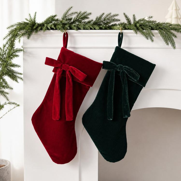 Pair of large velvet Christmas stockings, red and dark green with matching bows