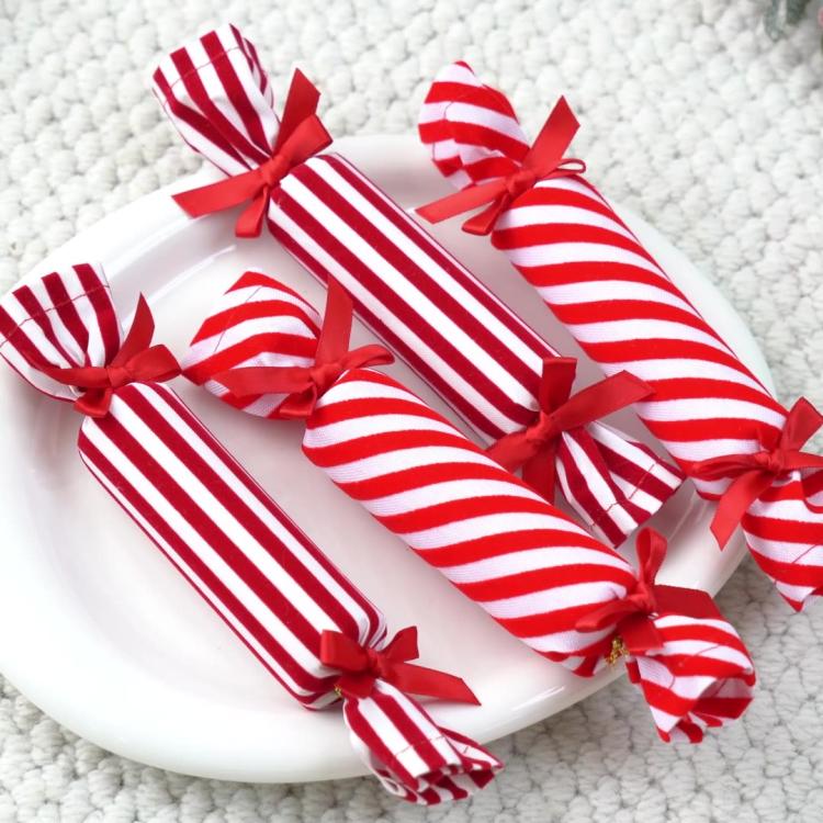 Red-and-white striped plush candy ornaments with ribbon bows on a plate