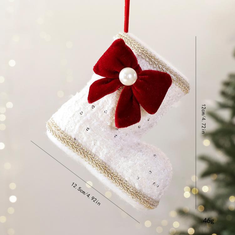 White fabric Christmas boot ornament with red velvet bow and pearl bead center.
