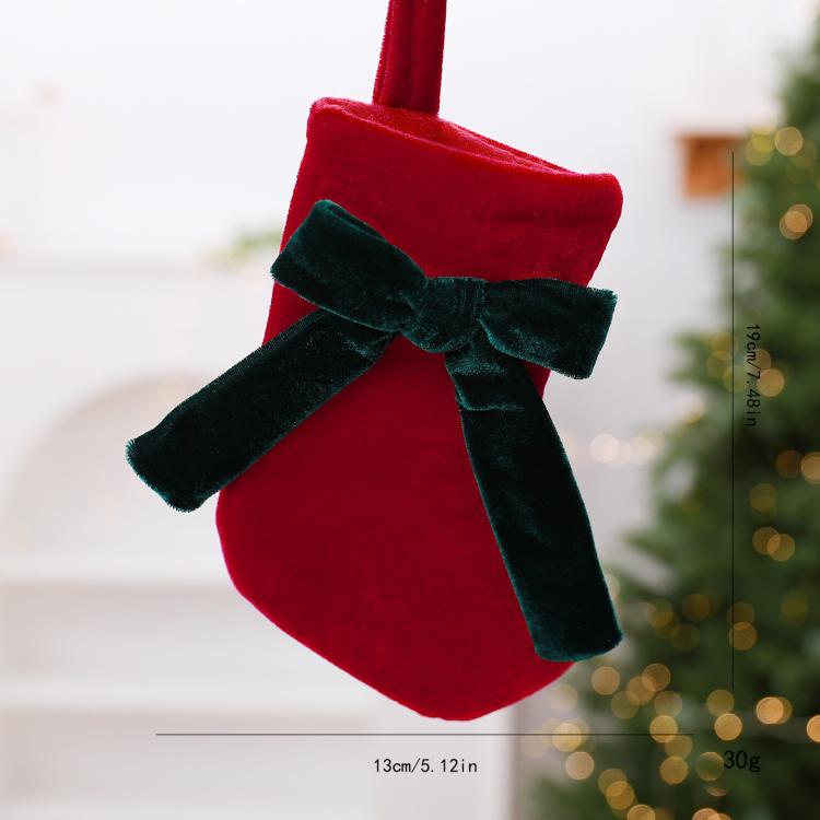 Red velvet hanging stocking ornament with dark green plush bow and ribbon