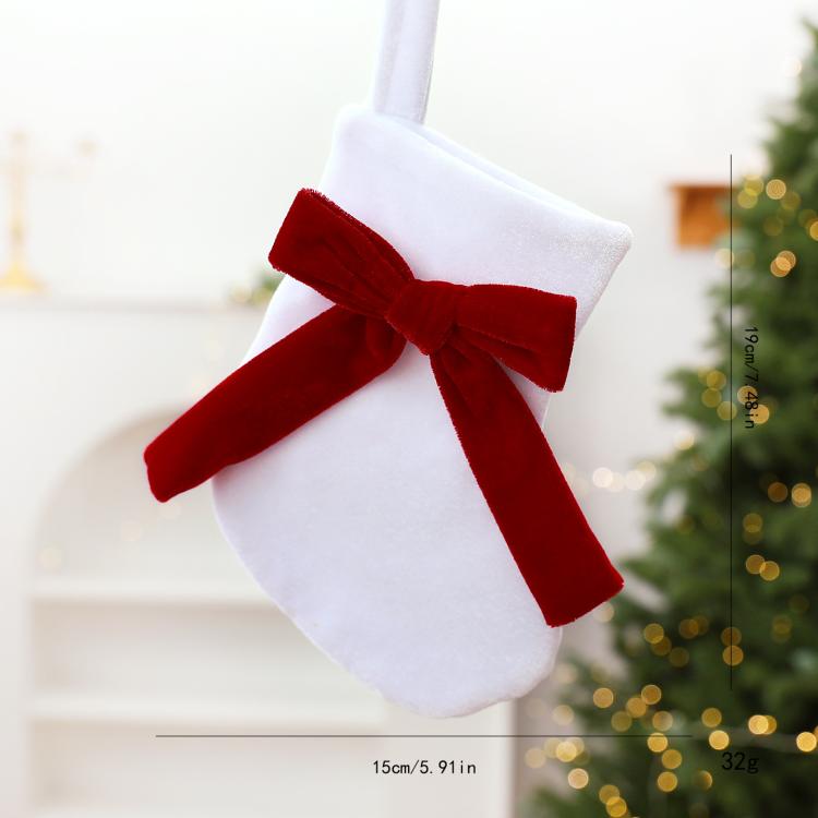 White fabric hanging stocking ornament with red bow and long ribbon tails