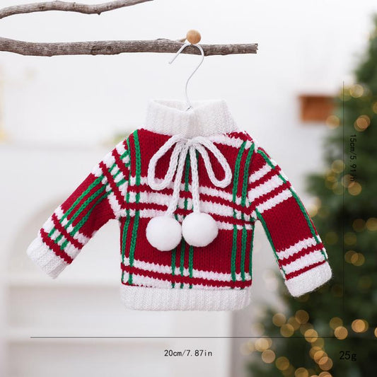 Mini knitted sweater ornament with red, green, and white stripes and pom pom accents.
