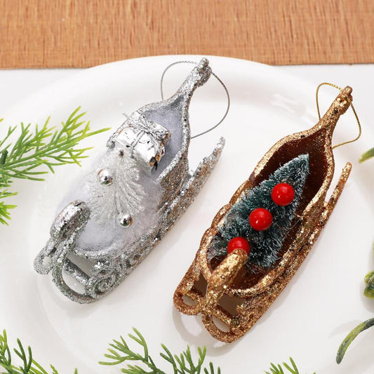 Pair of glitter sleigh ornaments: silver and gold, with pine-tree and red berry details