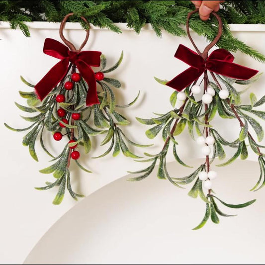 Pair of mistletoe hanging ornaments with red velvet bows and frosted greenery, red and white berries