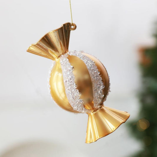 Gold candy-shaped Christmas ornament with silver glitter banding and hanging loop