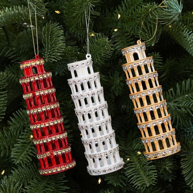 Diamond-studded leaning tower ornaments in red, white, and gold on evergreen branches