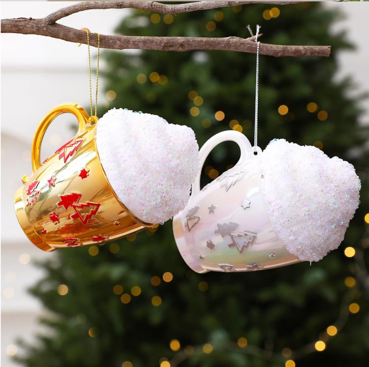 Hanging set of gold and white cup-shaped Christmas ornaments with glittered caps and charms