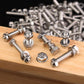 Stainless steel hex bolts and nuts scattered on a wooden board, mixed sizes
