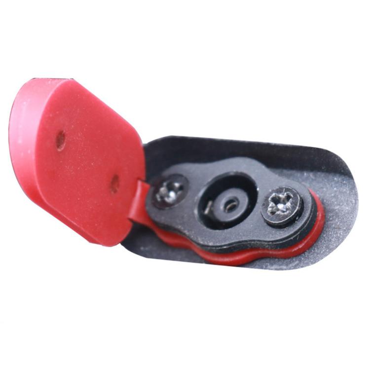 Charging port dust plug closeup with red cap and black mount