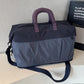 Lightweight duffel bag in dark navy with purple handle accents and shoulder strap