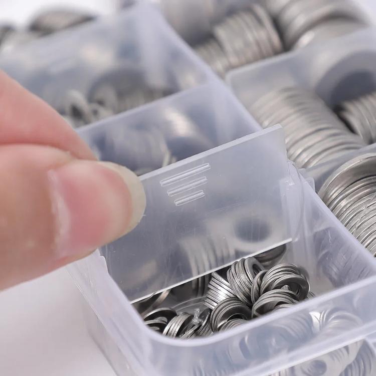 Close-up of stainless steel flat washers in a clear plastic compartment