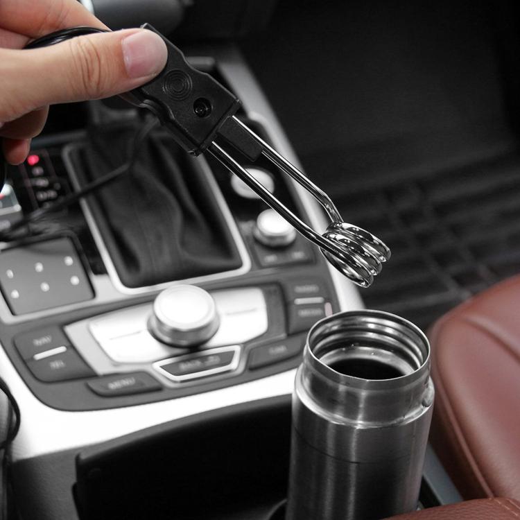 Hand holding a clip-on immersion heater rod beside a car cup container