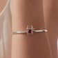 Sterling silver spider eye bracelet on wrist with red oval cabochon center