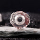 Pink glitter glass bead charm with silver skeleton-hand motif, back view and round hole