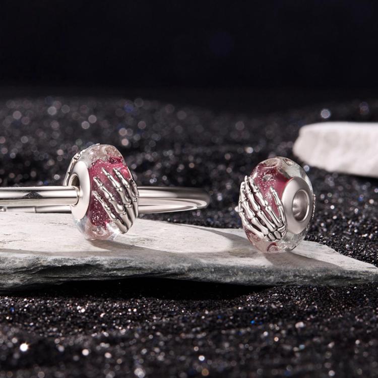 Silver bracelet with two pink glitter skeleton-hand glass bead charms
