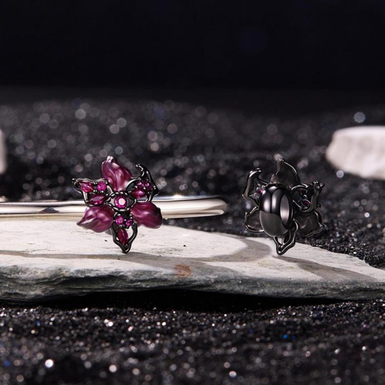 Devil flower charm with magenta enamel petals and pink gems on silver bracelet bar