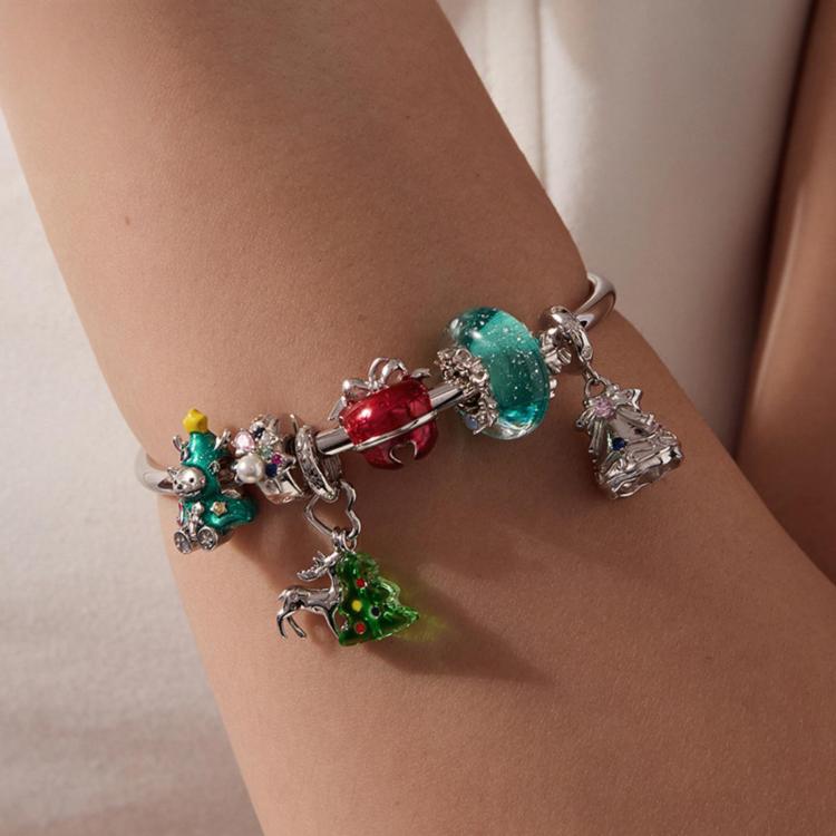 Charm bracelet on wrist with green tree dangle and aqua glass bead