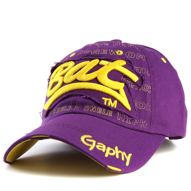 Purple baseball cap with yellow embroidered letter pattern and curved brim