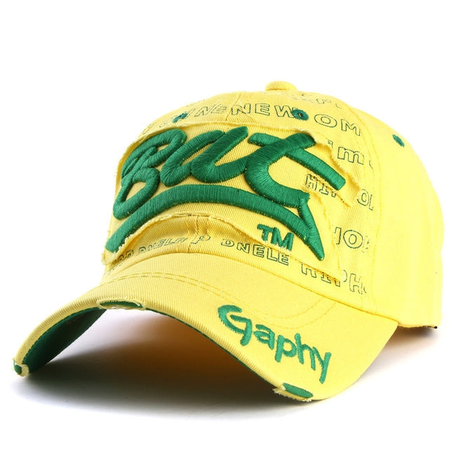 Light yellow baseball cap with green embroidered letter pattern and curved brim