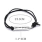 Black cord bracelet with silver bar and “never never give up!” text, 23.5cm length