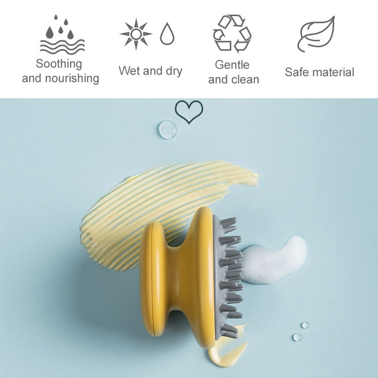Yellow silicone scalp massage brush with gray bristle tips, cleaning foam visible