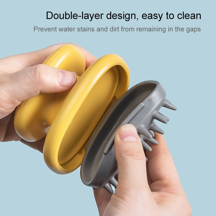 Yellow silicone scalp massage brush with removable gray bristle cover, close-up