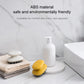 Yellow silicone scalp massage brush on countertop with marble-style tiles