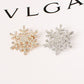 Gold- and silver-tone rhinestone snowflake brooches, two designs side by side