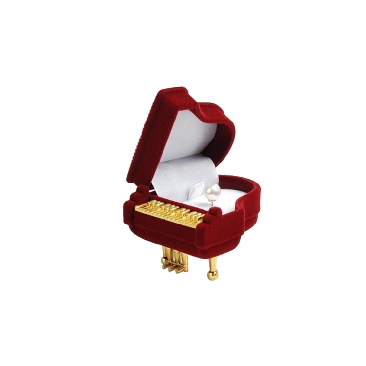 Red velvet piano-shaped jewelry box with lid open, gold front detail and pearl