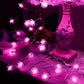 Pink pine cone LED string lights with vivid pink glowing bulbs on a connected wire