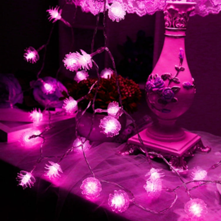 Pink pine cone LED string lights with vivid pink glowing bulbs on a connected wire