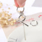 Hand holding silver-tone long asymmetric earrings with stacked hoops and a bar charm.