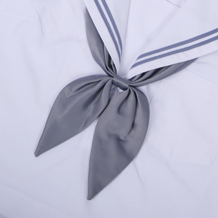 Goldfish-knot bow tie in gray with a centered knot on a white shirt collar.