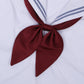 Goldfish-knot bow tie in claret red with a centered knot on a white shirt collar.