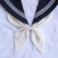 Goldfish-knot bow tie in white with dark navy ends and striped trim on a white shirt.