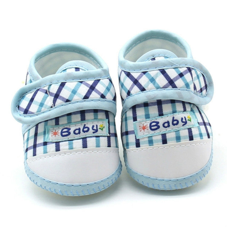 Pair of baby prewalker shoes with light blue plaid and “Baby” label on toe
