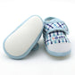 Baby prewalker shoes with blue plaid and “Baby” label, beige textured outsole