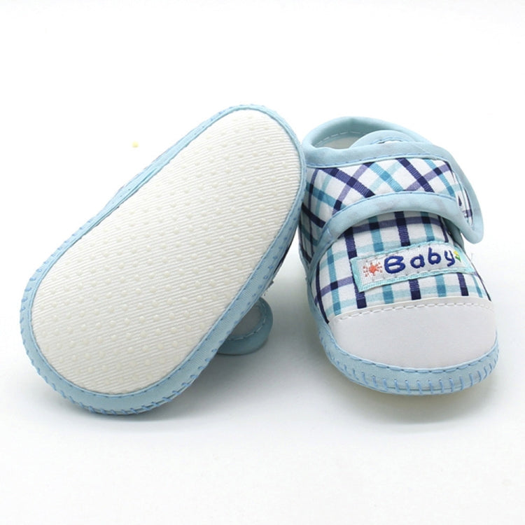 Baby prewalker shoes with blue plaid and “Baby” label, beige textured outsole
