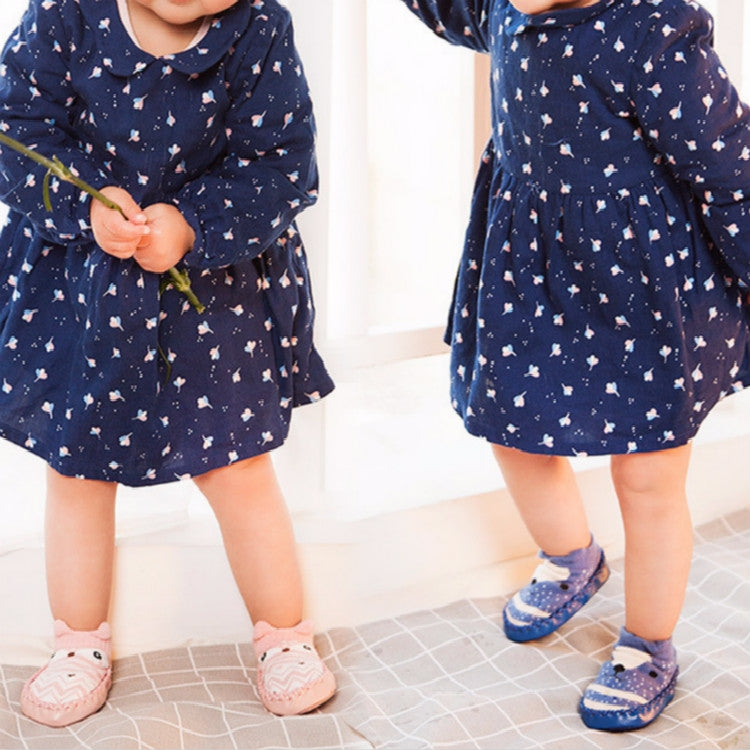 Light pink toddler non-slip socks with textured grip soles on a child’s feet