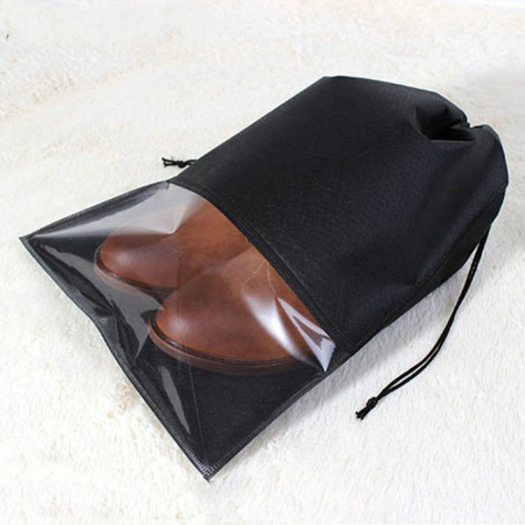 Black waterproof shoe pouch with transparent panel and drawstring, holding brown shoes