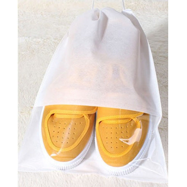 White drawstring shoe storage bag holding yellow sneakers, visible through clear front