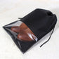 Black waterproof shoe storage pouch with clear window, holding brown shoes